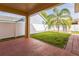 Covered patio with a view of the fenced in backyard featuring a decorative palm tree at 32717 Coldwater Creek Loop, Wesley Chapel, FL 33545