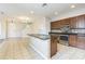 Eat-in kitchen features a kitchen island, stainless steel appliances, and tan tile floors at 32717 Coldwater Creek Loop, Wesley Chapel, FL 33545
