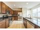 A kitchen is furnished with stainless steel appliances and dark brown cabinetry at 32717 Coldwater Creek Loop, Wesley Chapel, FL 33545