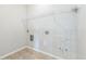 Bright laundry room features tile flooring, ample storage, and convenient hookups for washer and dryer at 32717 Coldwater Creek Loop, Wesley Chapel, FL 33545