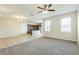 Open living area with tile flooring, carpet, and a view of the kitchen at 32717 Coldwater Creek Loop, Wesley Chapel, FL 33545