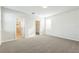 Main bedroom with neutral paint, plush carpet, and access to en suite and walk-in closet at 32717 Coldwater Creek Loop, Wesley Chapel, FL 33545