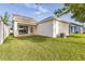 Backyard showing lawn with patio doors and view of adjacent home at 5254 Suncatcher Dr, Wesley Chapel, FL 33545