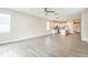 A light-filled open-concept living room into kitchen with modern gray tile flooring at 5254 Suncatcher Dr, Wesley Chapel, FL 33545