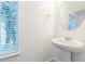The powder room offers a pedestal sink and a window with natural light at 5254 Suncatcher Dr, Wesley Chapel, FL 33545