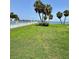 Green backyard and lawn overlooking the waterway, palm trees, and a community pool at 7310 Sunshine Skyway S Ln # 116, St Petersburg, FL 33711