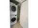 Convenient laundry closet with stacked washer and dryer, offering efficient space-saving design and functionality at 7310 Sunshine Skyway S Ln # 116, St Petersburg, FL 33711