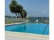Sparkling pool surrounded by lush tropical palms, lounge chairs, and serene waterfront views for relaxation at 7310 Sunshine Skyway S Ln # 116, St Petersburg, FL 33711