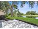 Private backyard featuring a paved patio, lush lawn, and serene pond views, perfect for outdoor entertaining and relaxation at 9555 Knightsbridge Cir, Sarasota, FL 34238