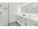 Modern bathroom with double vanity, white cabinetry, and a glass-enclosed shower featuring elegant tiling at 9555 Knightsbridge Cir, Sarasota, FL 34238