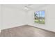 Bright bedroom with a ceiling fan and a large window with view of the front yard at 9555 Knightsbridge Cir, Sarasota, FL 34238