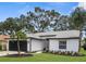 Beautiful home featuring a lush lawn, dark garage door, and a well-manicured tropical landscape at 9555 Knightsbridge Cir, Sarasota, FL 34238
