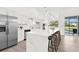 Spacious kitchen featuring a large center island with bar seating, modern appliances and bright natural light at 9555 Knightsbridge Cir, Sarasota, FL 34238