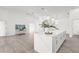 Open concept kitchen with a spacious island, modern pendant lights, and a seamless flow to the living area at 9555 Knightsbridge Cir, Sarasota, FL 34238
