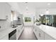 Modern kitchen with white cabinets, quartz countertops, and stainless steel appliances overlooking a lush backyard at 9555 Knightsbridge Cir, Sarasota, FL 34238
