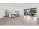 Bright open-concept living space with kitchen island, sliding glass doors to a screened-in patio, and tile floors at 9555 Knightsbridge Cir, Sarasota, FL 34238