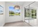 Bright sun room featuring a decorative chandelier and sliding glass doors to a serene outdoor view at 9555 Knightsbridge Cir, Sarasota, FL 34238