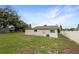 Backyard view of the home's exterior with a partial fence and some trees at 103 4Th Nw Ave, Lutz, FL 33548