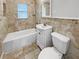 Tiled bathroom featuring a shower-tub combo, a vanity with storage, and a toilet at 103 4Th Nw Ave, Lutz, FL 33548