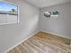 Bedroom featuring wood-look flooring, neutral walls, and natural light from two windows at 103 4Th Nw Ave, Lutz, FL 33548