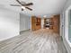 Open-concept living room flowing into the kitchen with wood-look flooring and a ceiling fan at 103 4Th Nw Ave, Lutz, FL 33548