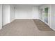 Neutral-toned living room with carpet, white trim, glass paneled doors, and a view of the backyard at 103 4Th Nw Ave, Lutz, FL 33548