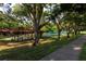 Community with covered picnic area and tennis courts shaded by mature trees at 1122 Montrose Pl # 1713, Dunedin, FL 34698