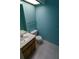 Cozy powder room with a tiled floor, single sink vanity, toilet, and stylish light blue walls at 1122 Montrose Pl # 1713, Dunedin, FL 34698