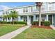 Charming light blue townhome featuring a well-manicured lawn and tropical landscaping at 11622 Colony Lake Dr, Tampa, FL 33635