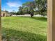 Expansive backyard with lush green lawn, mature trees, and a white fence at 37601 Georgina Ter, Zephyrhills, FL 33542