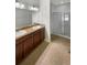Bathroom featuring dual sinks, a shower and tile floors at 37601 Georgina Ter, Zephyrhills, FL 33542