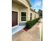 Side view of home featuring manicured landscaping and a private walkway at 37601 Georgina Ter, Zephyrhills, FL 33542