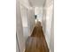 Hallway with wood floors and white trim leading to various rooms at 37601 Georgina Ter, Zephyrhills, FL 33542