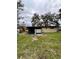 Illustrates the back of the house with a small screened area, integrated within a grassy yard setting at 5026 Osprey Ln, New Port Richey, FL 34652