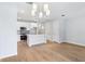 Open-concept kitchen with white cabinets, stainless steel appliances, and wood-look tile flooring at 7292 Deer Valley Circle, Tampa, FL 33635