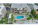 Aerial view of condo complex, highlighting the swimming pool, landscaping and beach access at 19700 Gulf Blvd # 204, Indian Shores, FL 33785
