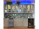 Stylish bar area featuring glass-front cabinets, marble counters, backsplash, wine fridge and beverage center at 19700 Gulf Blvd # 204, Indian Shores, FL 33785