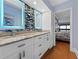 Modern bathroom with dual sinks, granite counters, decorative tile and mirrors with custom lighting at 19700 Gulf Blvd # 204, Indian Shores, FL 33785