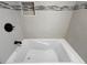 Modern bathroom featuring a luxurious soaking tub with sleek, neutral tile and recessed shelving at 19700 Gulf Blvd # 204, Indian Shores, FL 33785