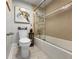 Well-lit bathroom with a modern toilet, glass-enclosed tub-shower, and seaside decor at 19700 Gulf Blvd # 204, Indian Shores, FL 33785