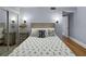 Cozy bedroom with hardwood floors, mirrored closet, nautical decor, and sconce lighting at 19700 Gulf Blvd # 204, Indian Shores, FL 33785
