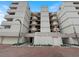 Contemporary condo building featuring private balconies, well-kept landscaping, and a view of the parking area at 19700 Gulf Blvd # 204, Indian Shores, FL 33785