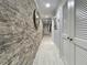 Hallway featuring stone wall, inset lights, tile floor, and white doors at 19700 Gulf Blvd # 204, Indian Shores, FL 33785