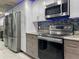 Modern kitchen featuring stainless steel appliances, bright white upper cabinets, and attractive backsplash at 19700 Gulf Blvd # 204, Indian Shores, FL 33785