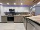 Modern kitchen with stainless steel appliances, gray cabinetry, and under-cabinet lighting at 19700 Gulf Blvd # 204, Indian Shores, FL 33785