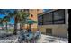 Outdoor dining area with seating for eight, and grill, shaded by a large umbrella at 19700 Gulf Blvd # 204, Indian Shores, FL 33785