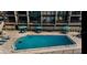 A clear blue swimming pool, complimented with patio seating and views of the condo building at 19700 Gulf Blvd # 204, Indian Shores, FL 33785