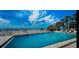 Outdoor swimming pool with beach views, lounge chairs and palm trees on a sunny day at 19700 Gulf Blvd # 204, Indian Shores, FL 33785