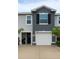 Close up of townhome exterior featuring an attached garage, tidy landscaping, and a covered entryway at 2913 Suncoast Plains Dr, Odessa, FL 33556