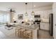 Open kitchen with a center island, white cabinets, stainless appliances, and seating for three at 2913 Suncoast Plains Dr, Odessa, FL 33556